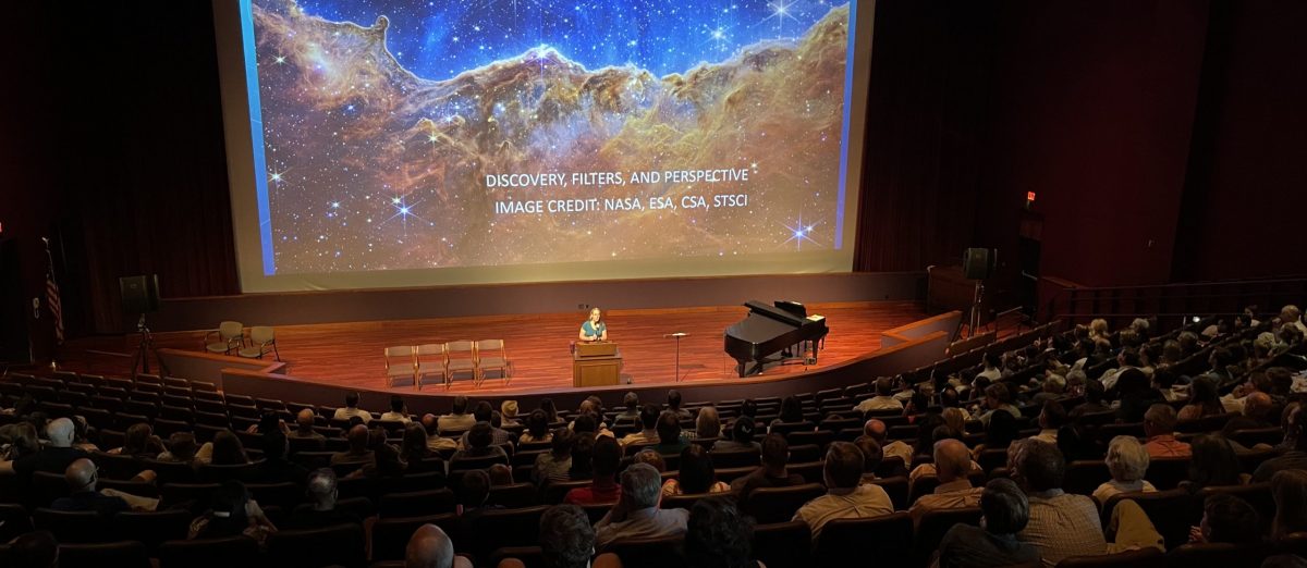 Denise Stephens speaking to a crowd in the Washington DC Temple Visitors' Center Auditorium during the Worlds Without Number: God's Infinite Creation exhibit.